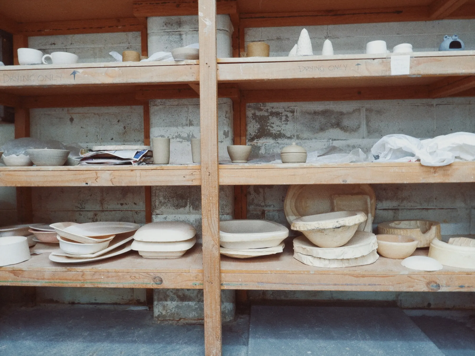 Pottery studio interior with shelves, work benches, and natural light